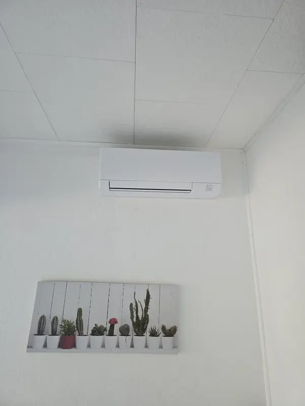Climatiseur mural installé sous un plafond en dalles