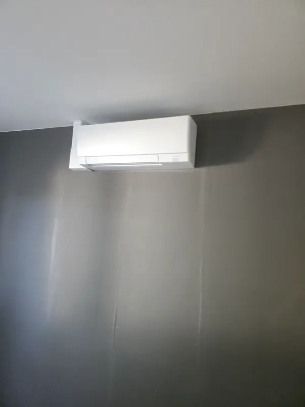 Climatiseur mural blanc sur un mur gris anthracite